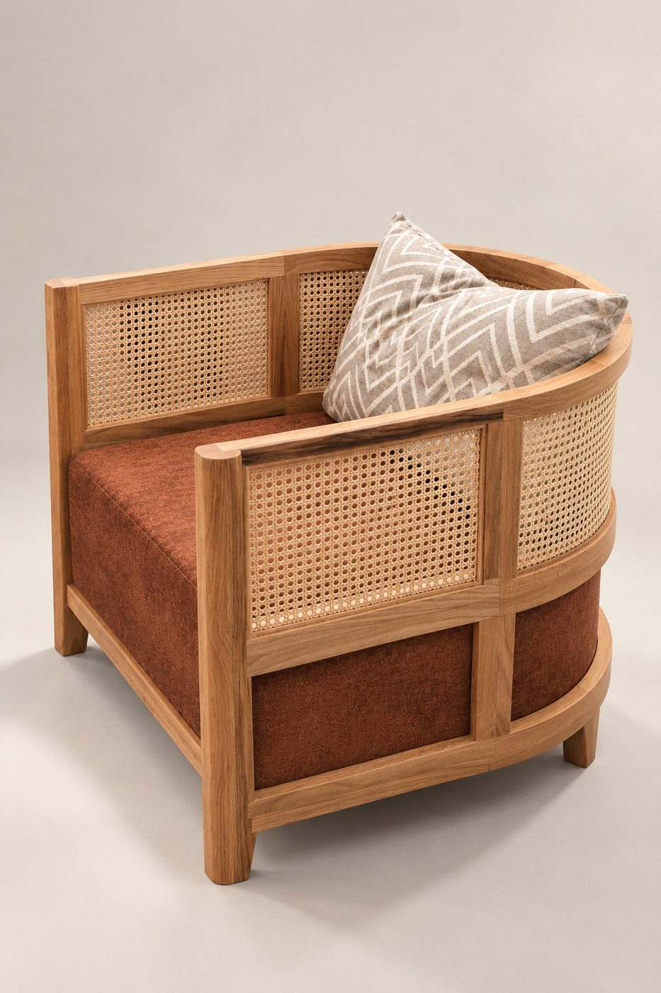 Poltrona de madera con respaldo de rejilla de ratán y asiento tapizado en tono terracota, vista en tres cuartos