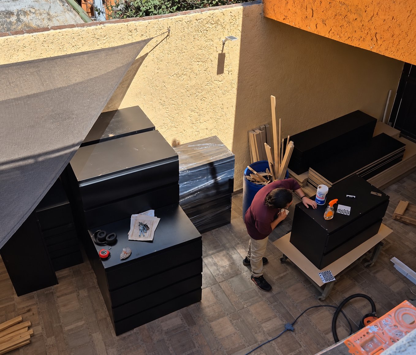 Módulos negros de clóset terminados y apilados en el patio del taller mientras se limpian
